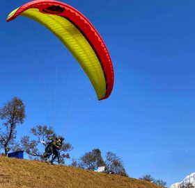 प्याराग्लाइडिङमार्फत आकाशमा उड्ने तयारी गर्दै पर्यटक